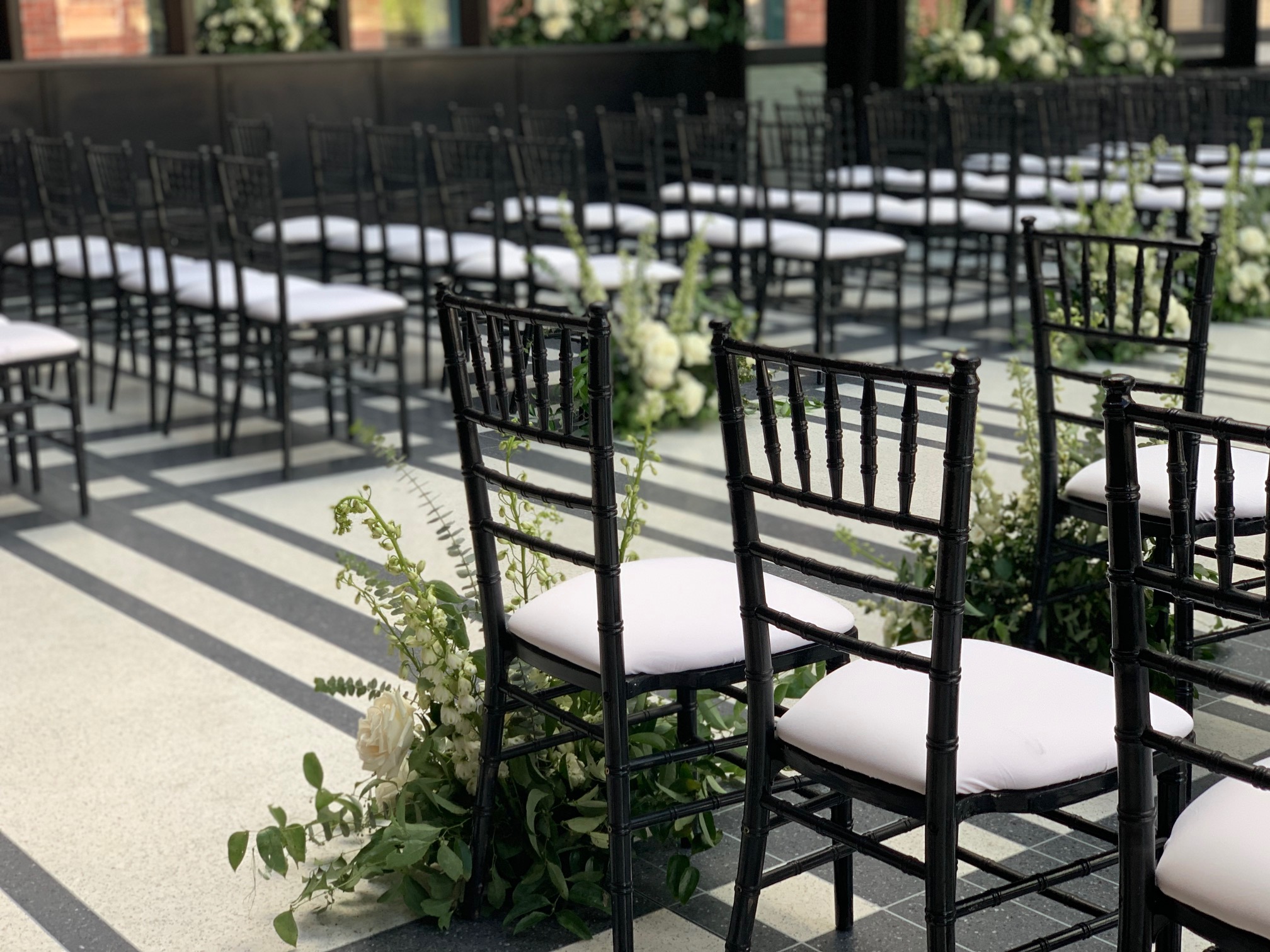 Chairs and flowers at an outdoor wedding are pictured here.