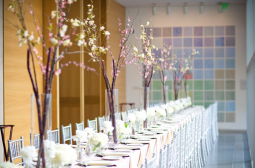 Wedding reception table set with plates, silverware, glasses, and flowers